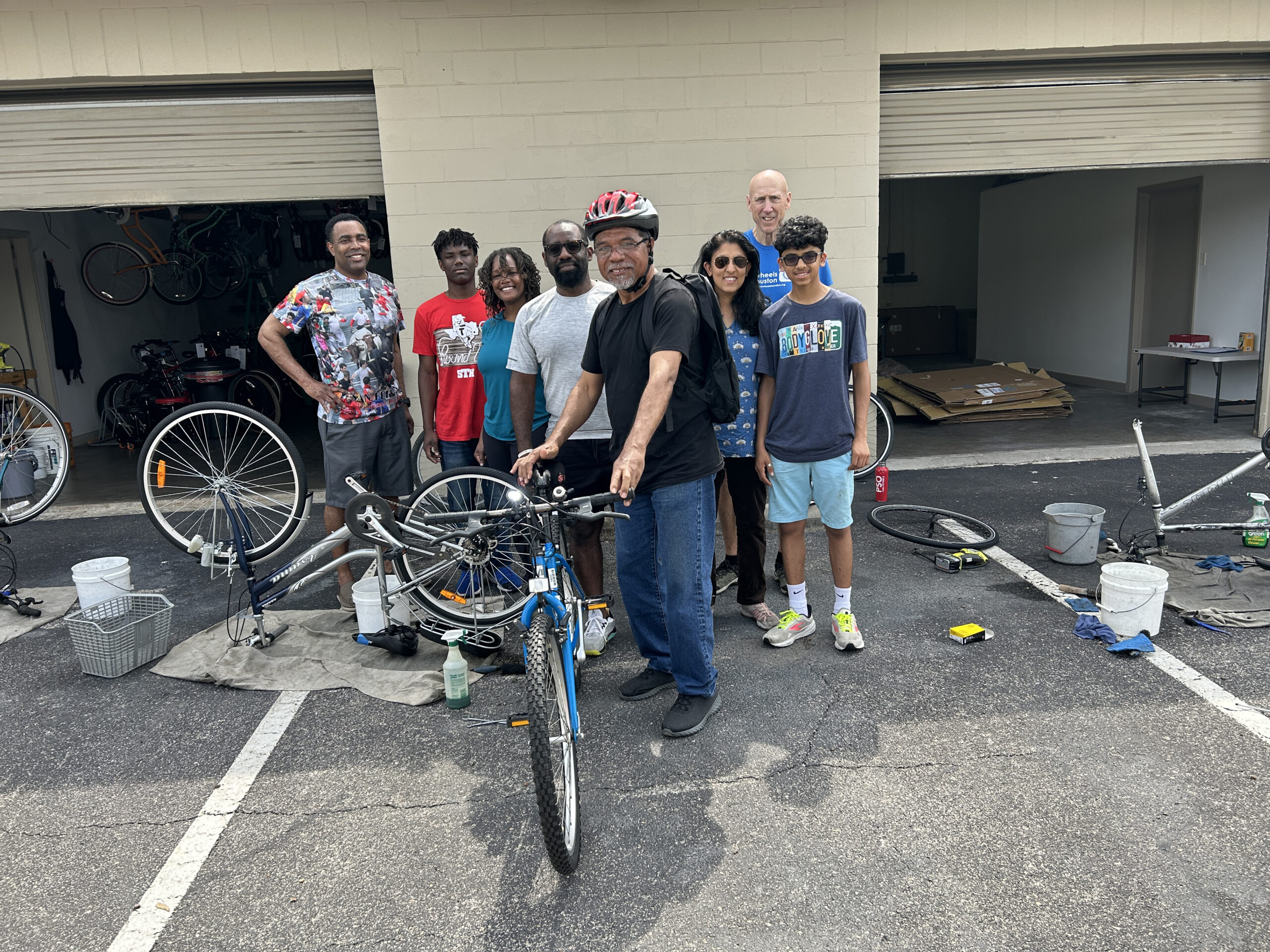 A group of people standing around a bike.