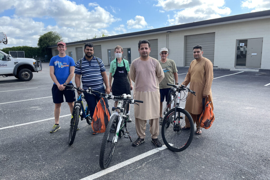 A group of people standing next to bikes.