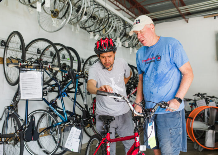 Freewheels volunteer with refugee receiving a refurbished bike